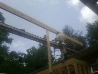 Carpenter setting a ridge beam over a new addition frame — Ice Dam Removal by Roofing Brothers in Gerrardstown