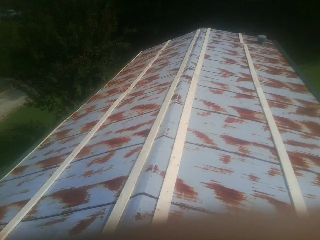 Rusted metal roof panels with new wood purlins before replacement — Storm Damage Roof Repair in Gerrardstown by Roofing Brothers